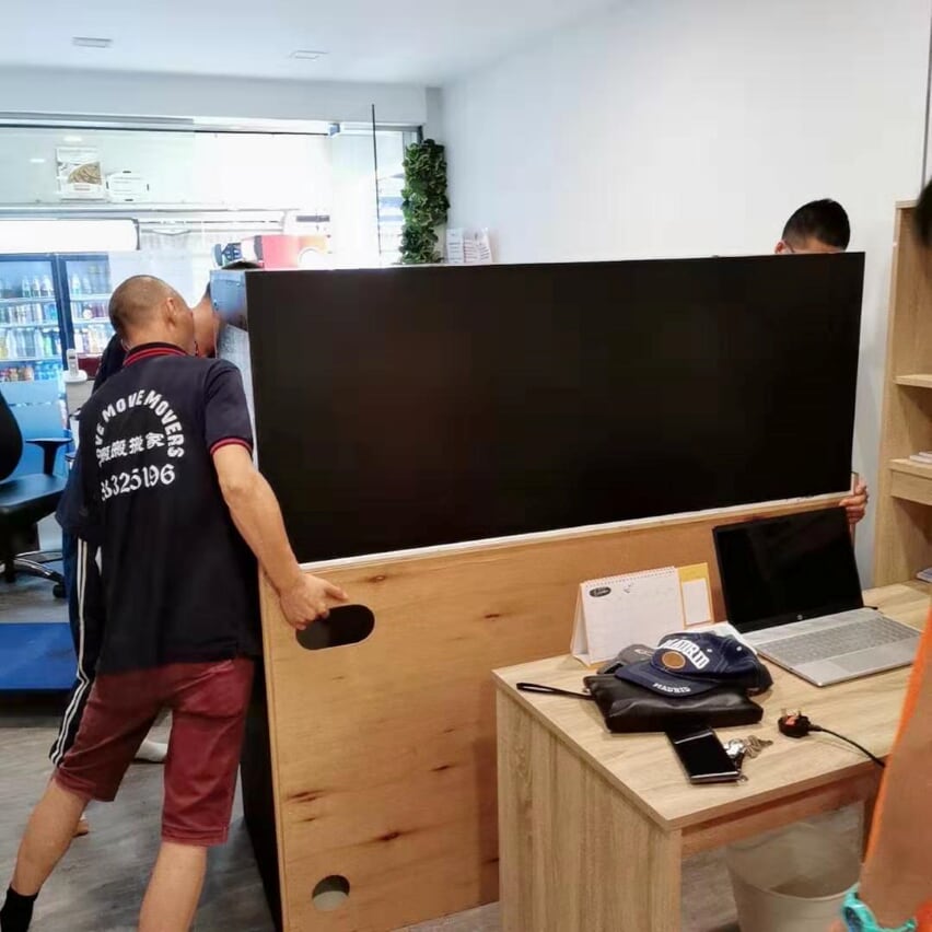 Office desk panel handling - move move movers – move move movers – move move movers Move Move Movers crew carrying a large desk panel inside a Singapore office