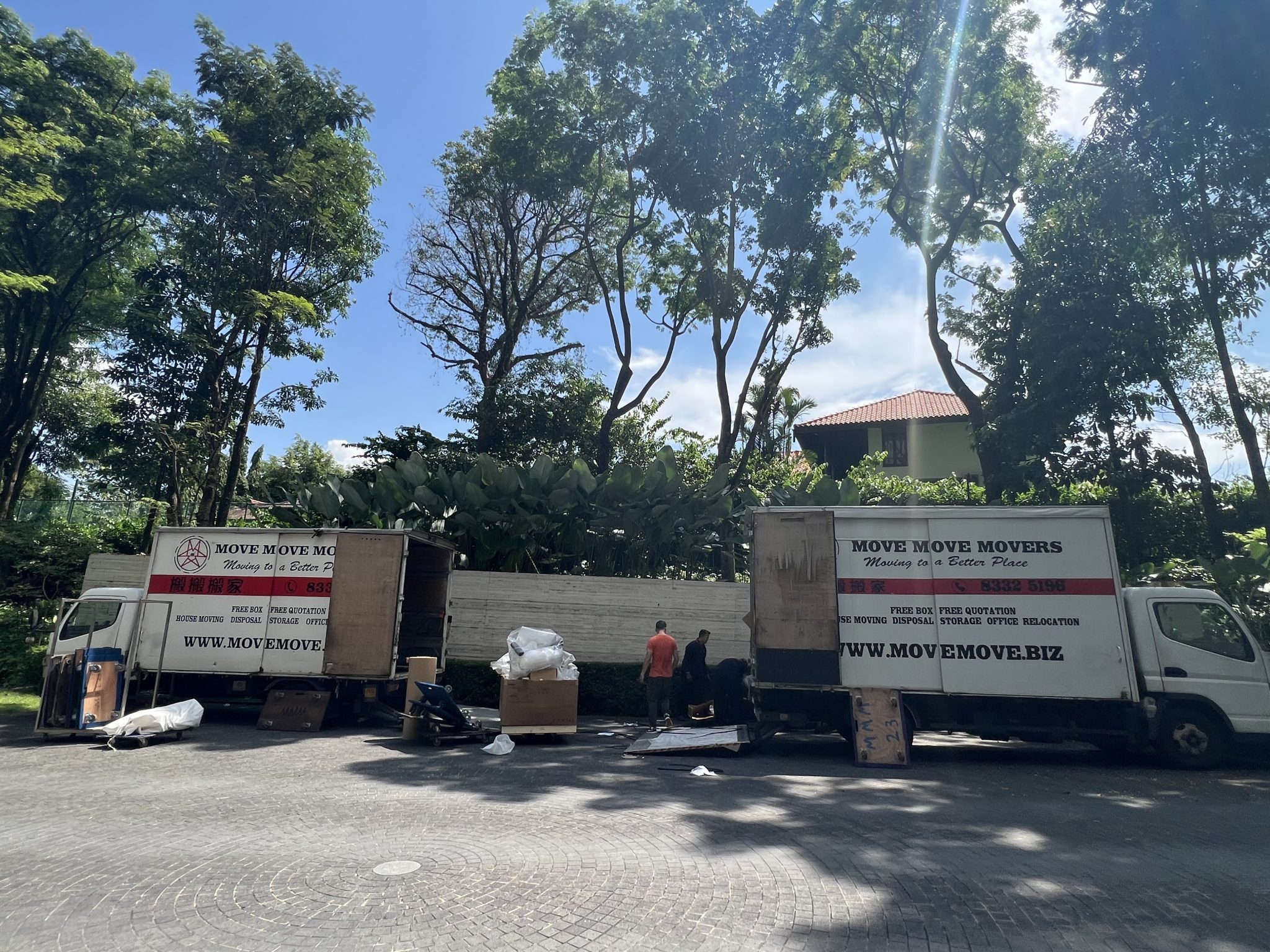 Singapore condo moving crew working in daytime heat with protected furniture handling