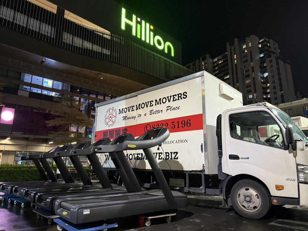 Row of treadmills staged beside a Move Move truck at night