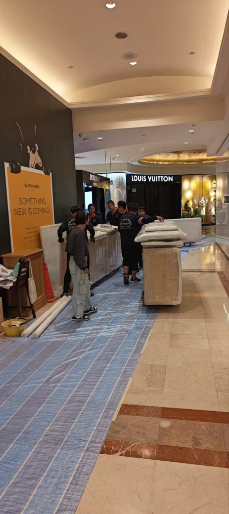 Move Move Movers crew using floor protection mats while moving wrapped items through a property route