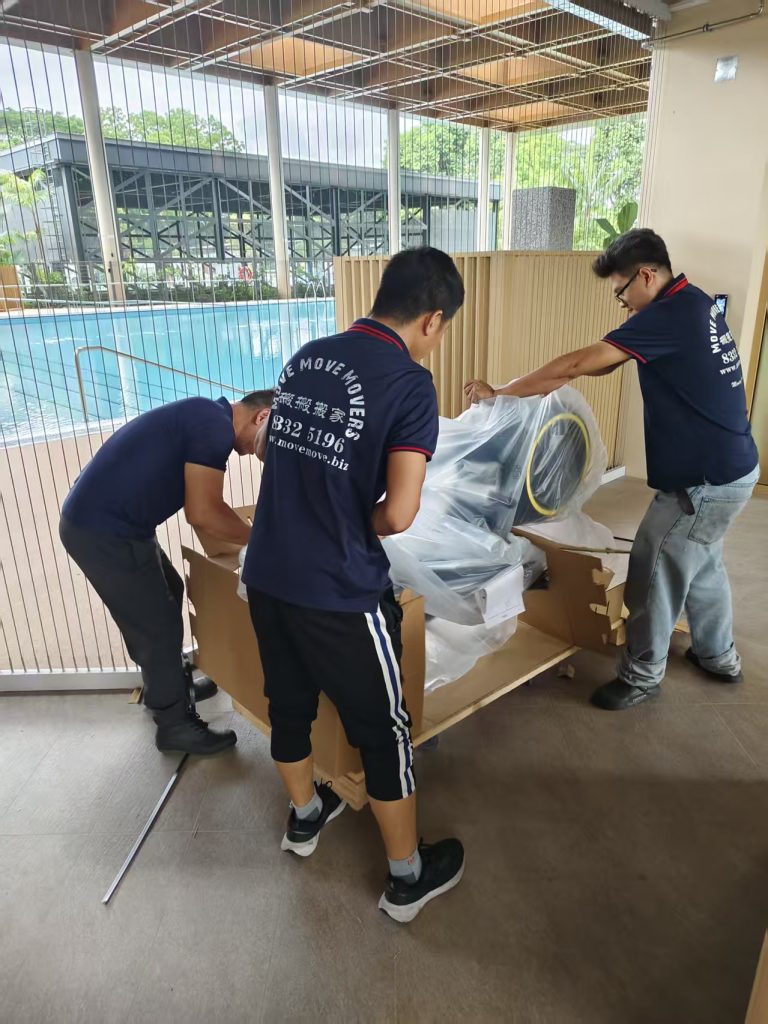 Crew adjusting protective wrap on gym equipment parts near an indoor poolside area