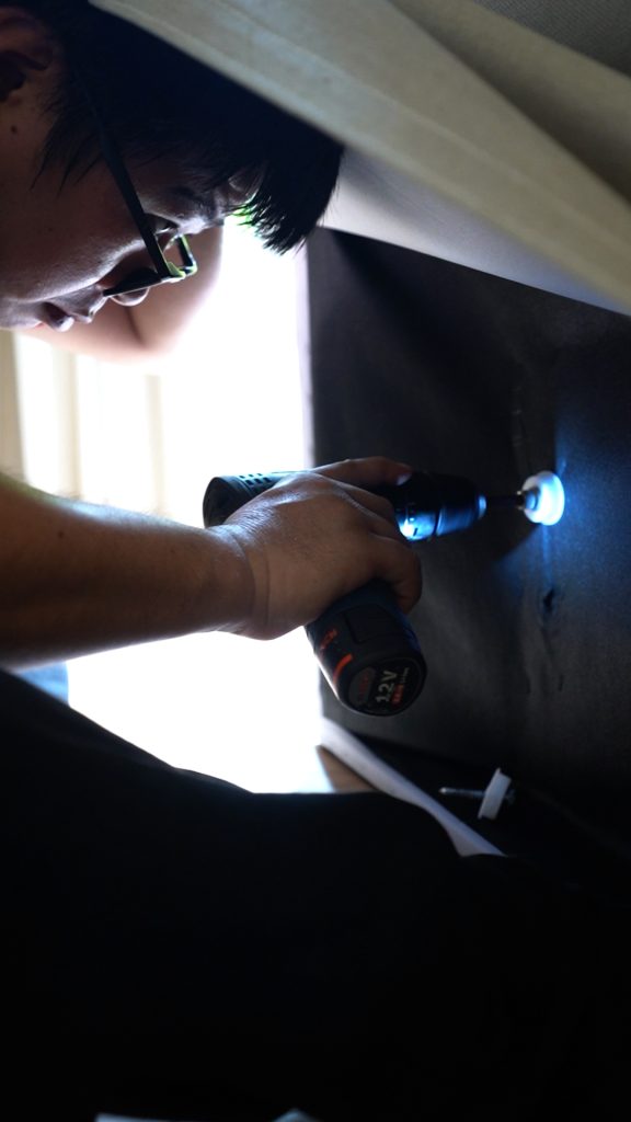 Technician using a power tool to dismantle furniture before moving