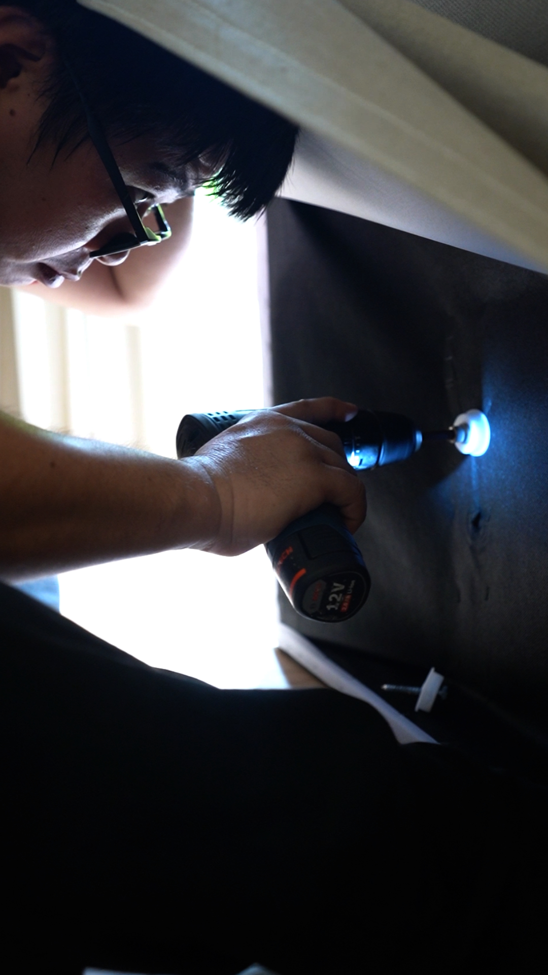 Technician using a power tool to dismantle furniture before disposal in Singapore