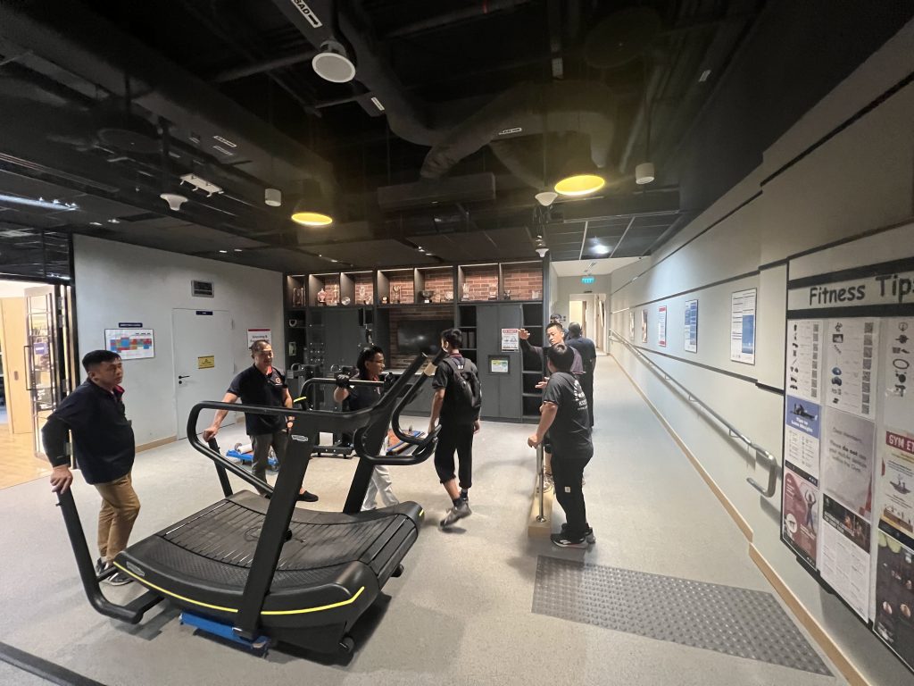 Move Move Movers crew positioning commercial gym equipment inside a Singapore fitness facility