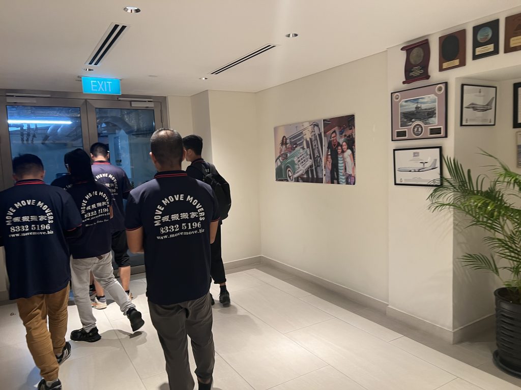 Move Move Movers crew in branded navy uniforms coordinating a controlled building corridor route