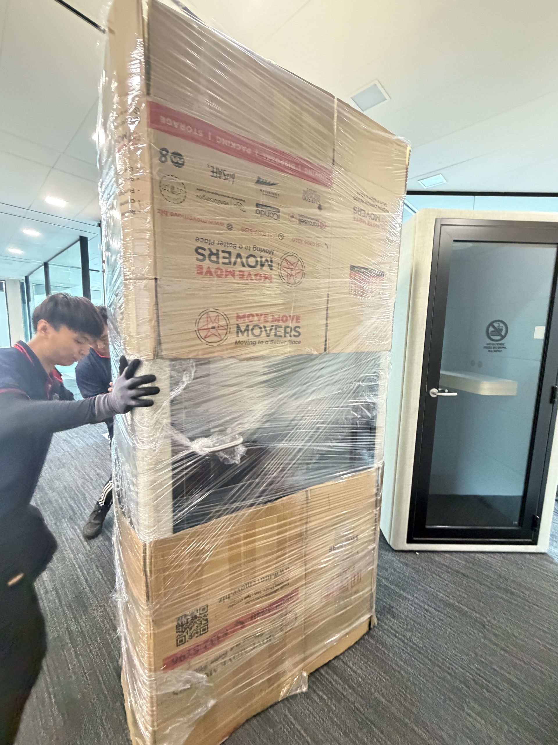 Wrapped office crate moving through hallway – move move movers – move move movers Move Move Movers team using trolley and access planning for a moving job in Singapore
